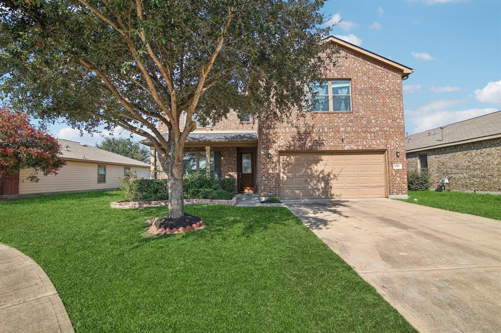 a front view of a house with a yard and trees