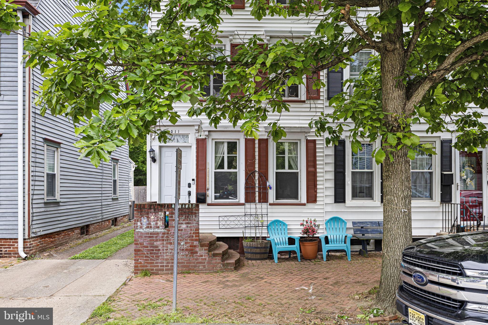 a view of a brick house with a chairs in a patio