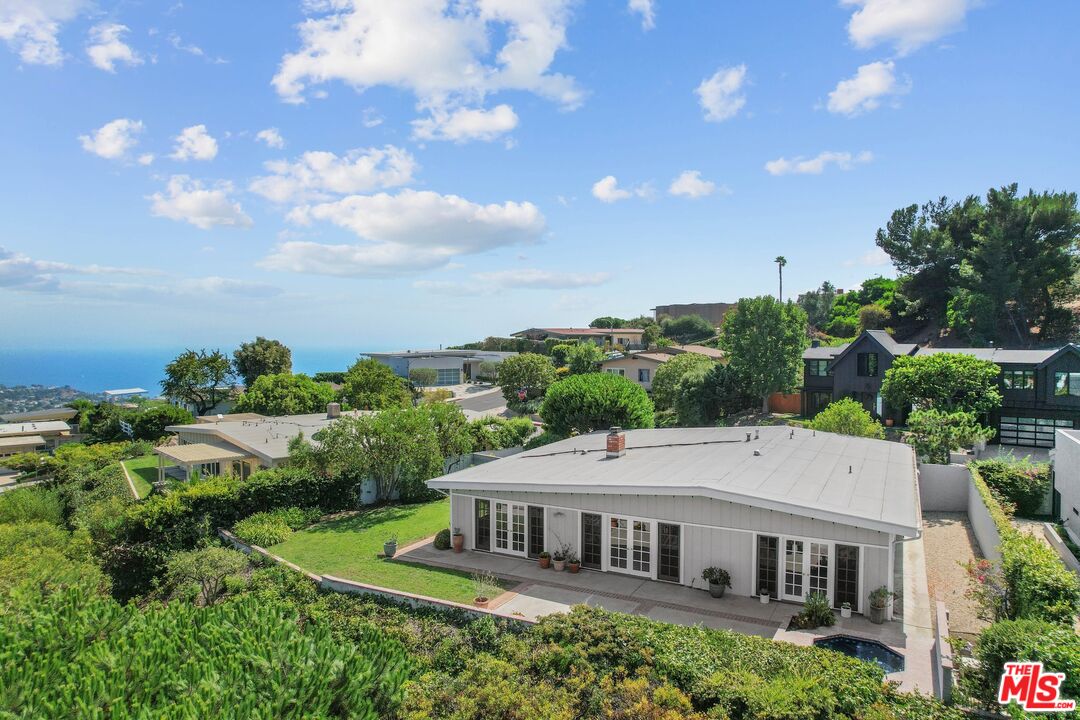 an aerial view of a house with yard and green space