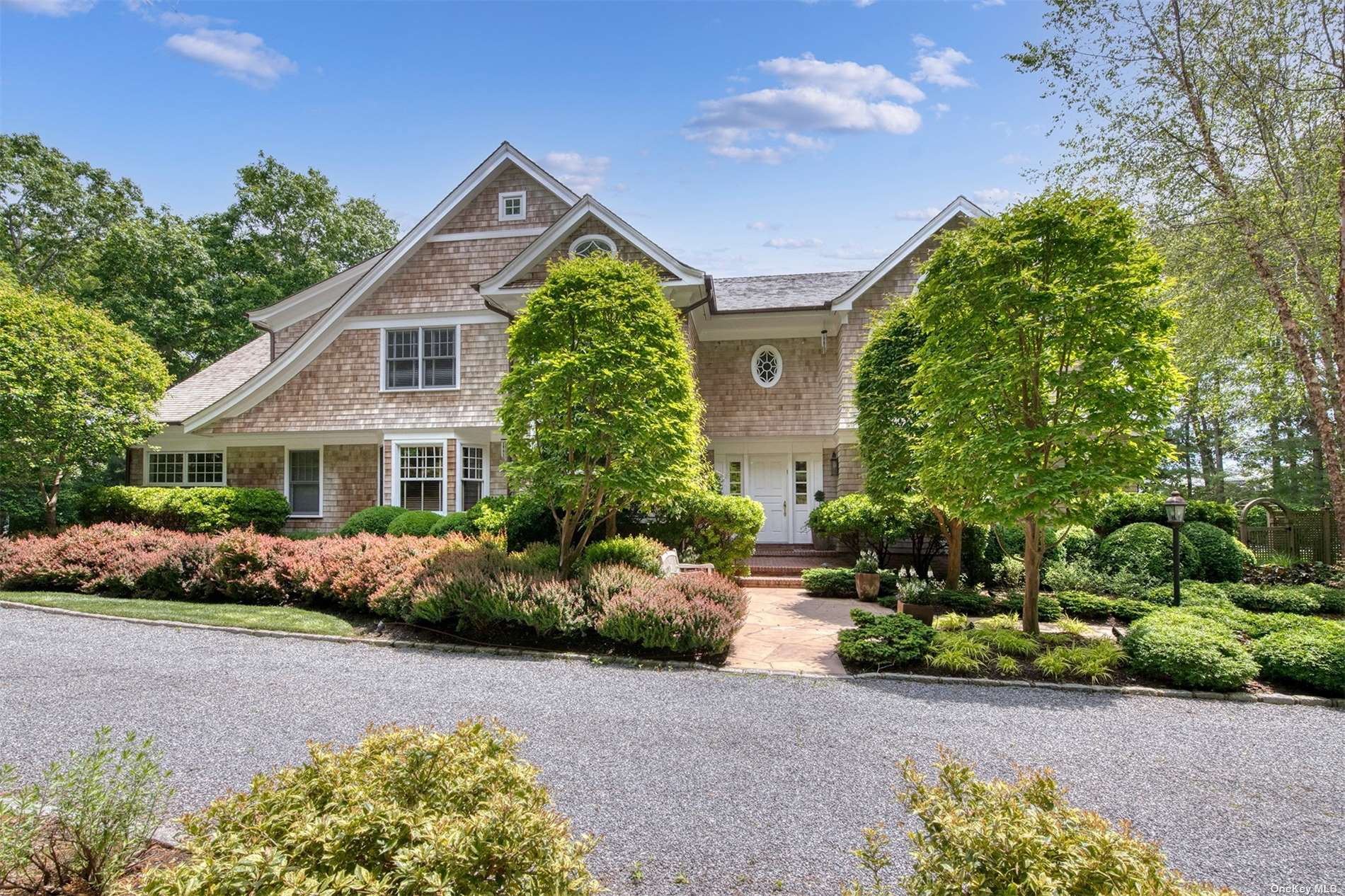 a front view of a house with a yard and potted plants