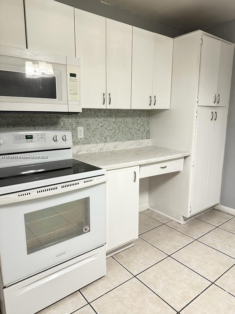 a stove top oven sitting inside of a kitchen