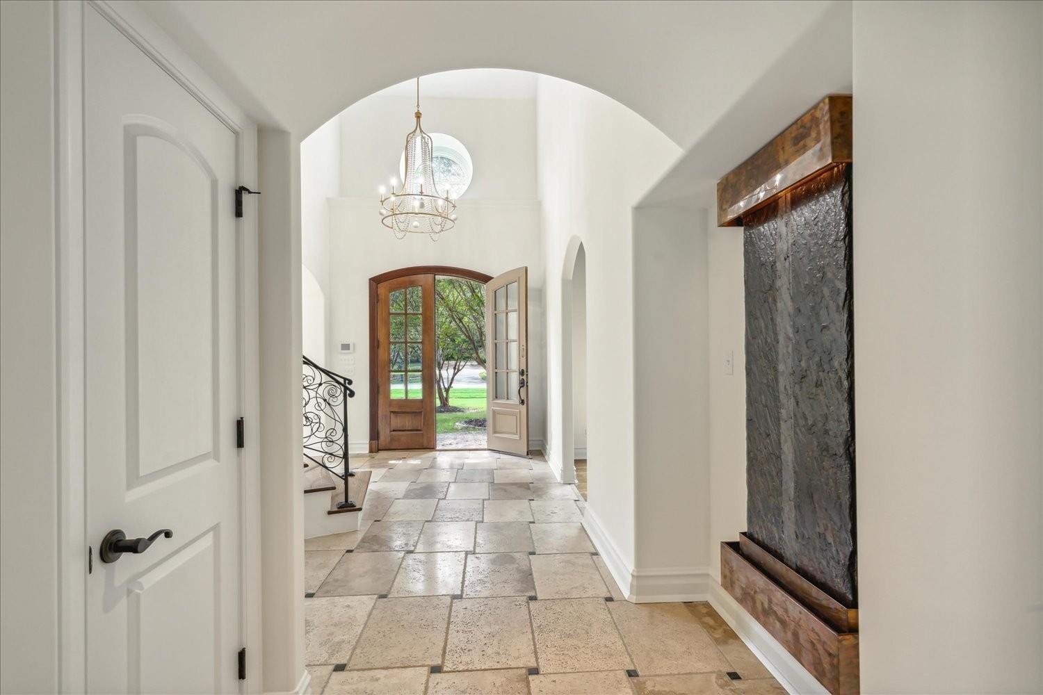 Hallway with a notable chandelier