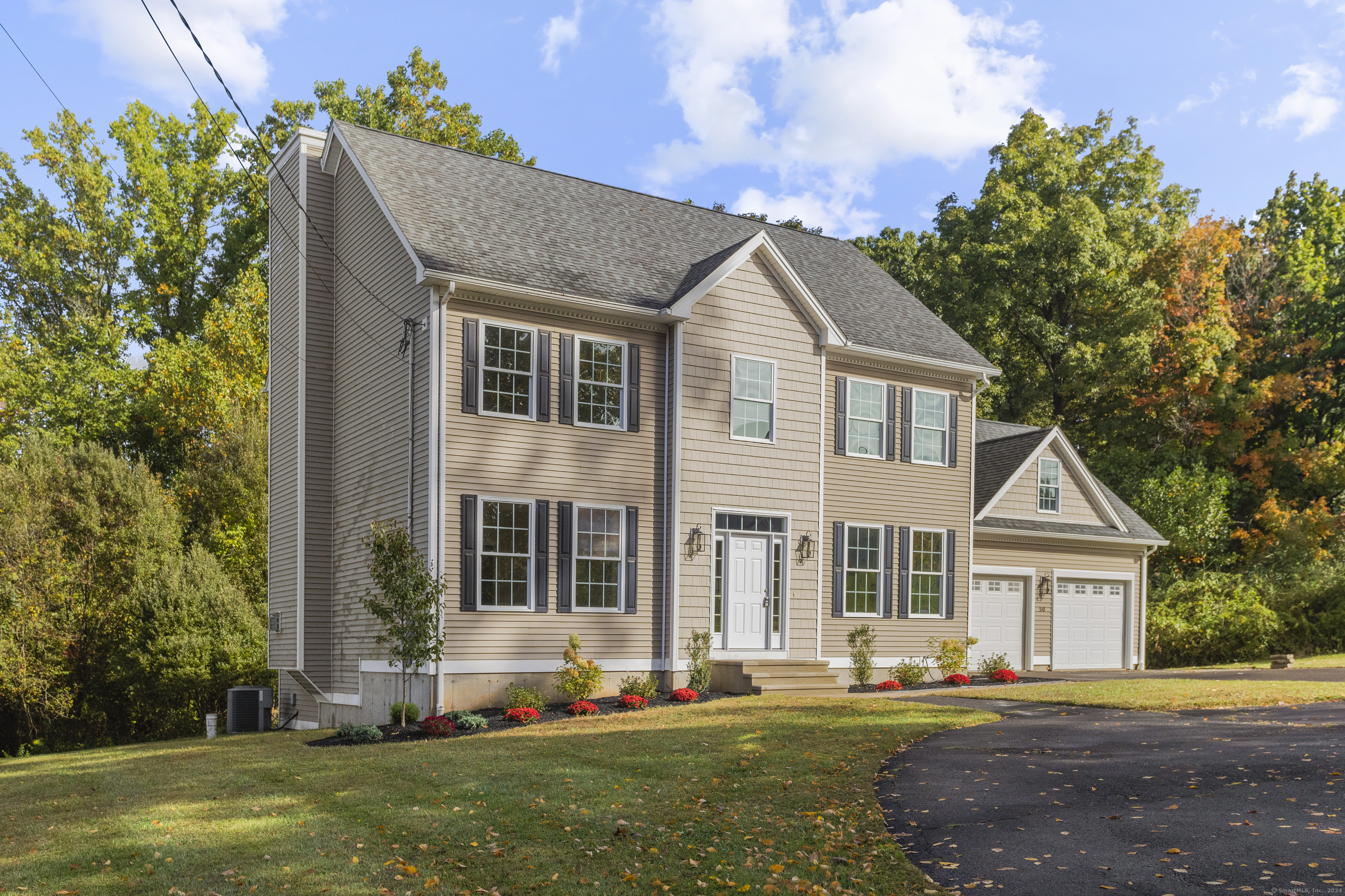 a front view of a house with a yard and trees