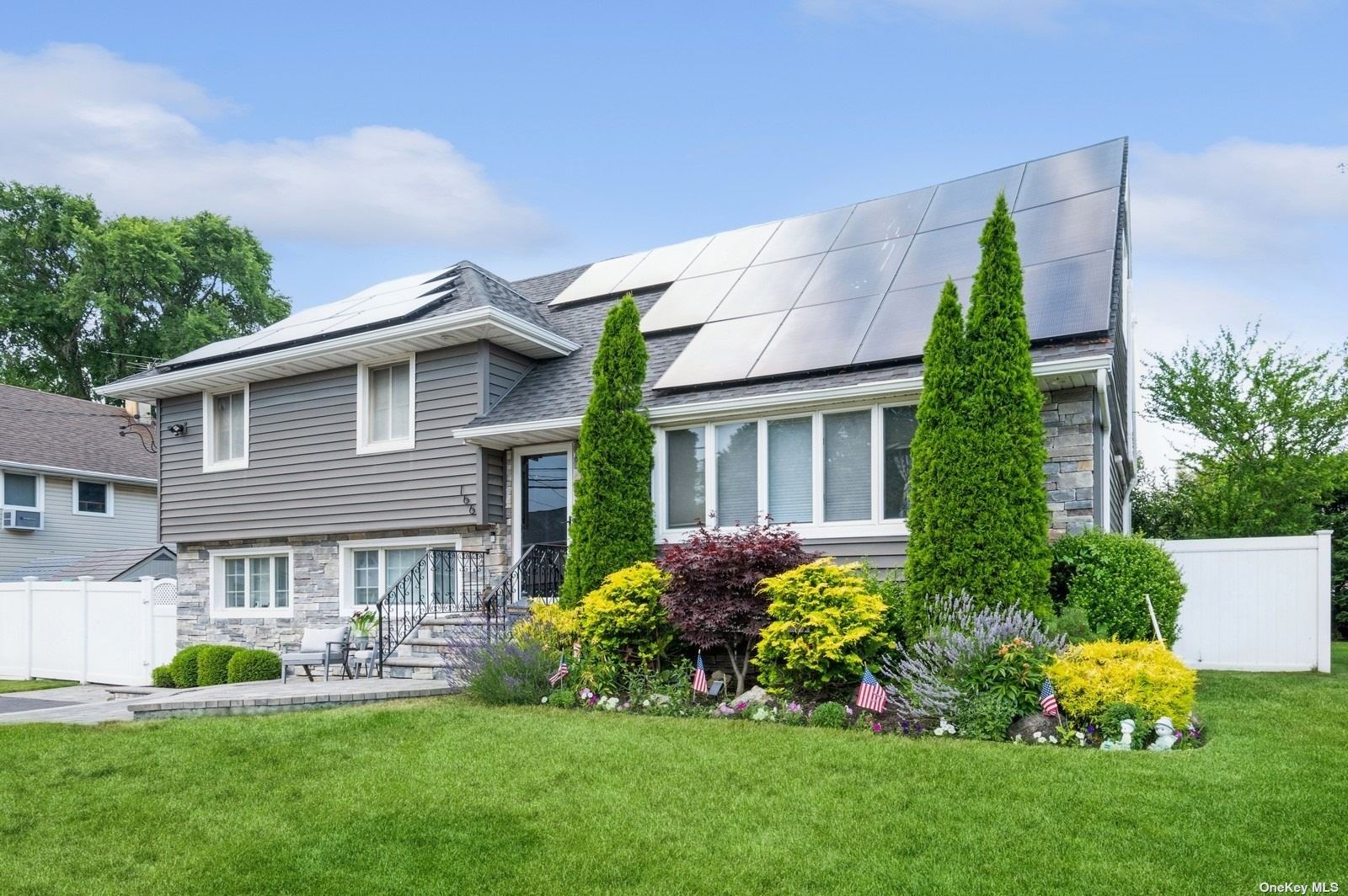 a front view of a house with a garden and plants