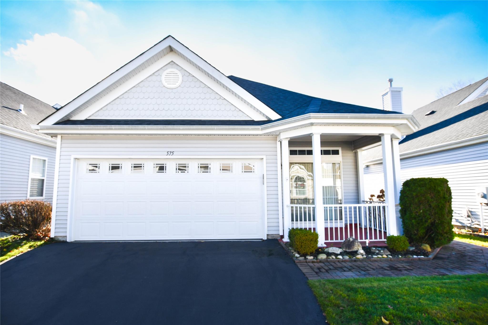 View of front of home with a porch and a garage