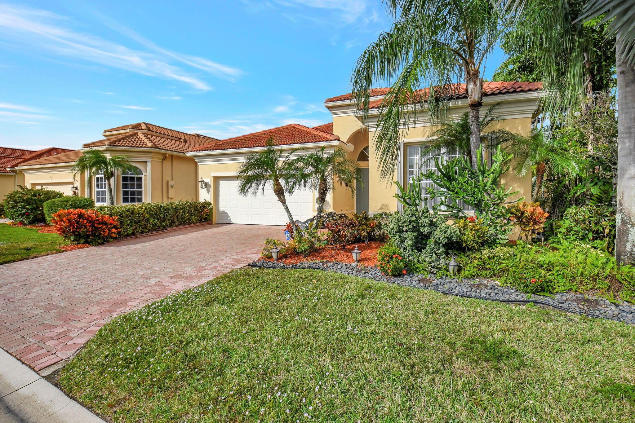 a front view of a house with a yard and potted plants