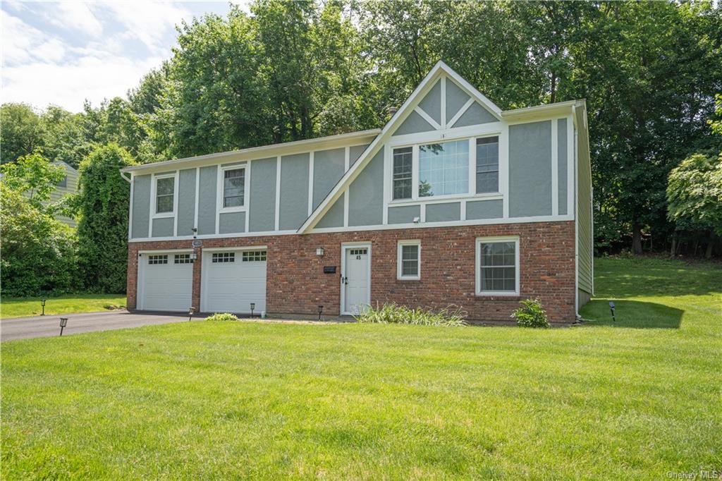 a front view of a house with yard and green space