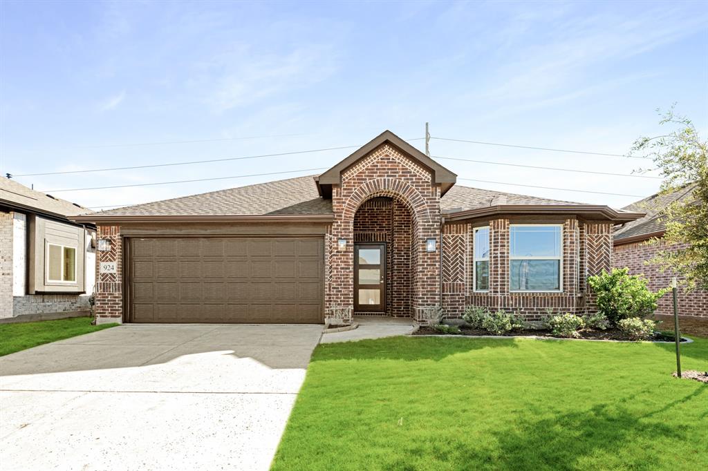 a front view of a house with a garden and garage