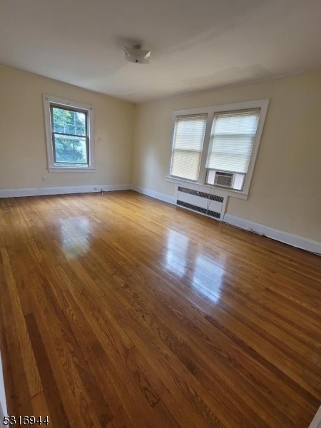 a view of a room with wooden floor and window