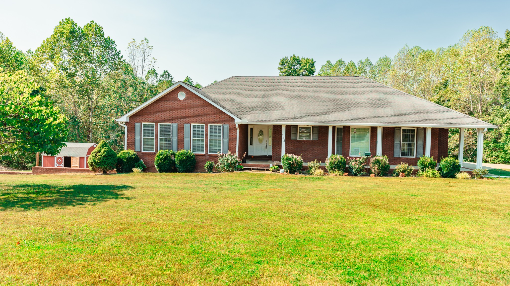 a front view of a house with yard and green space