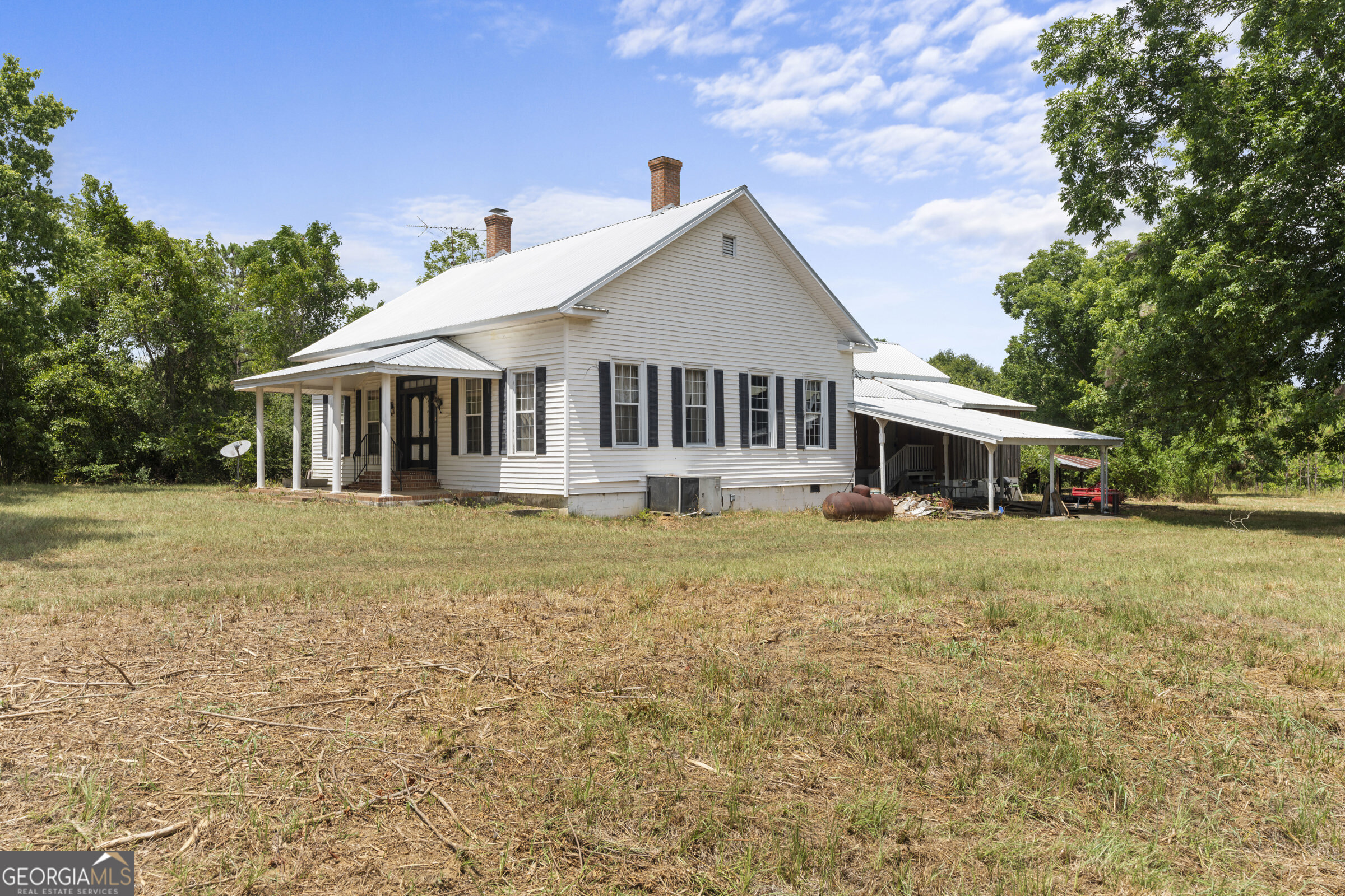 a front view of a house with a garden and trees