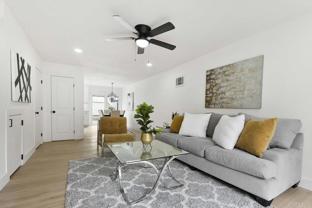 a living room with furniture and a ceiling fan