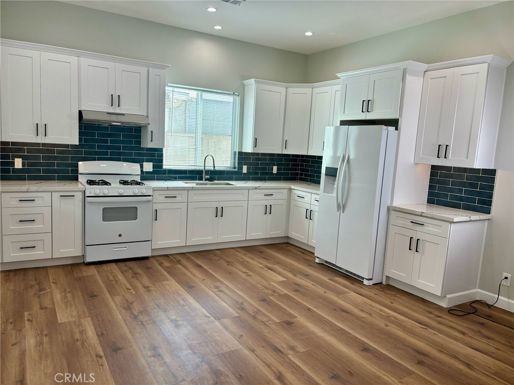 a kitchen with granite countertop white cabinets and stainless steel appliances