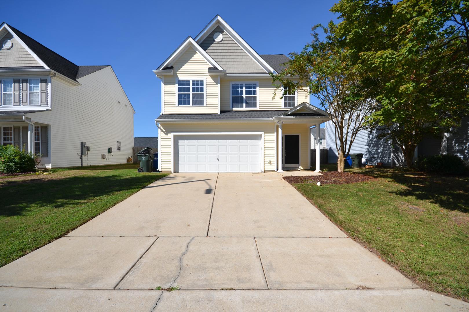 a front view of a house with a yard and trees