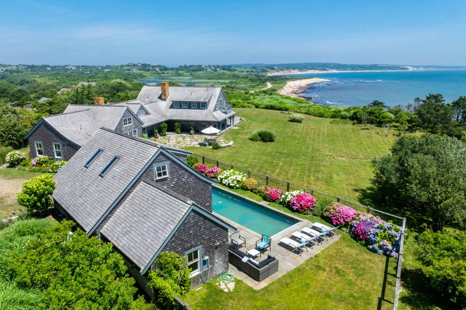 an aerial view of a house with a garden and lake view