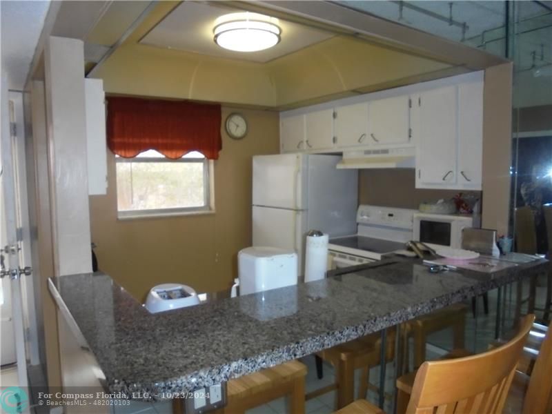 a kitchen with stainless steel appliances granite countertop a sink and a stove