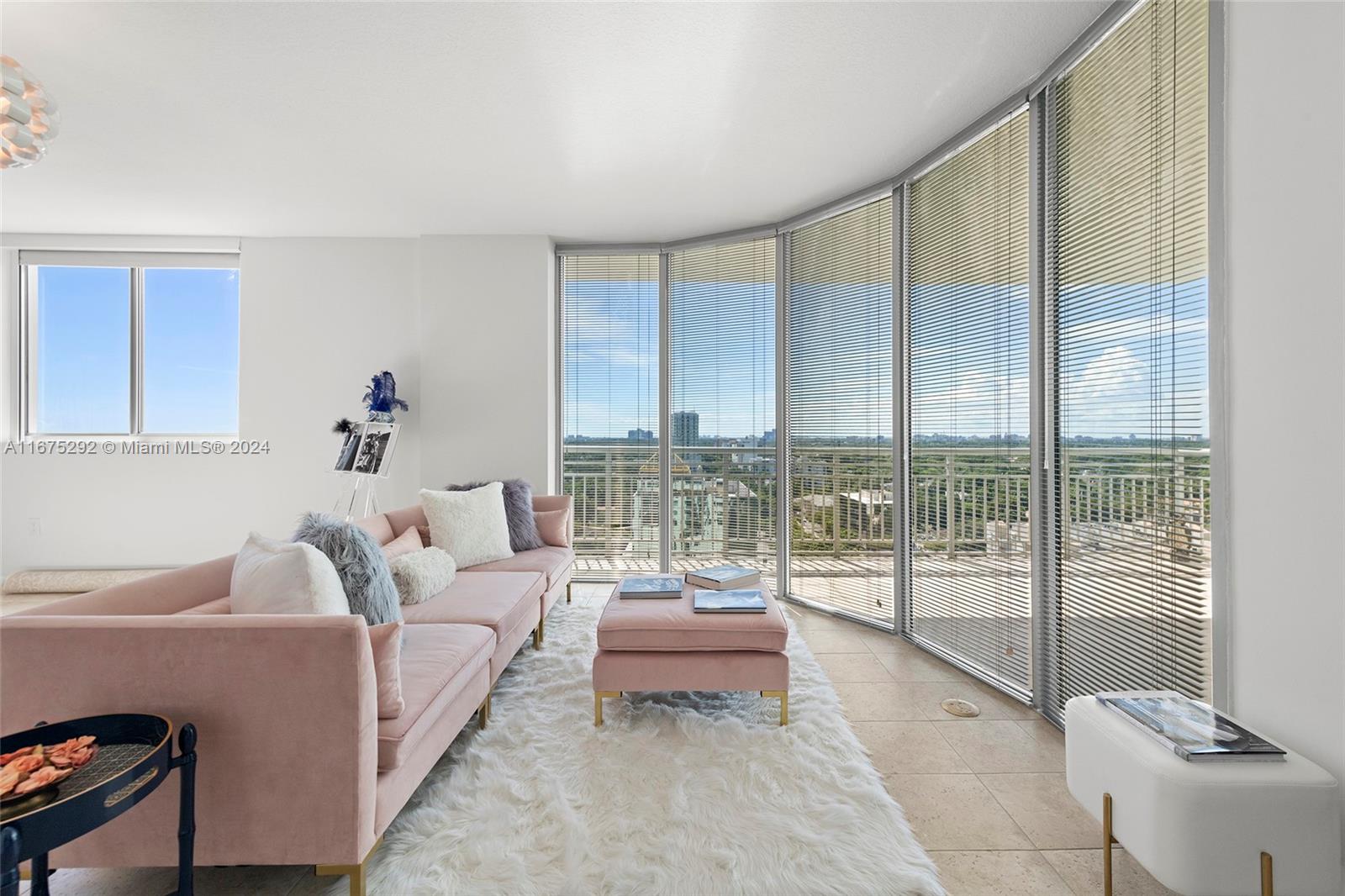 a living room with furniture and a floor to ceiling window