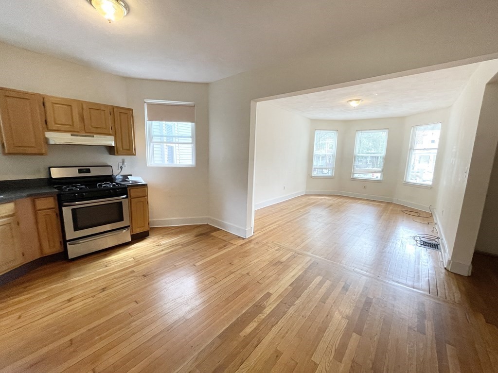 a view of a kitchen with wooden floor and electronic appliances