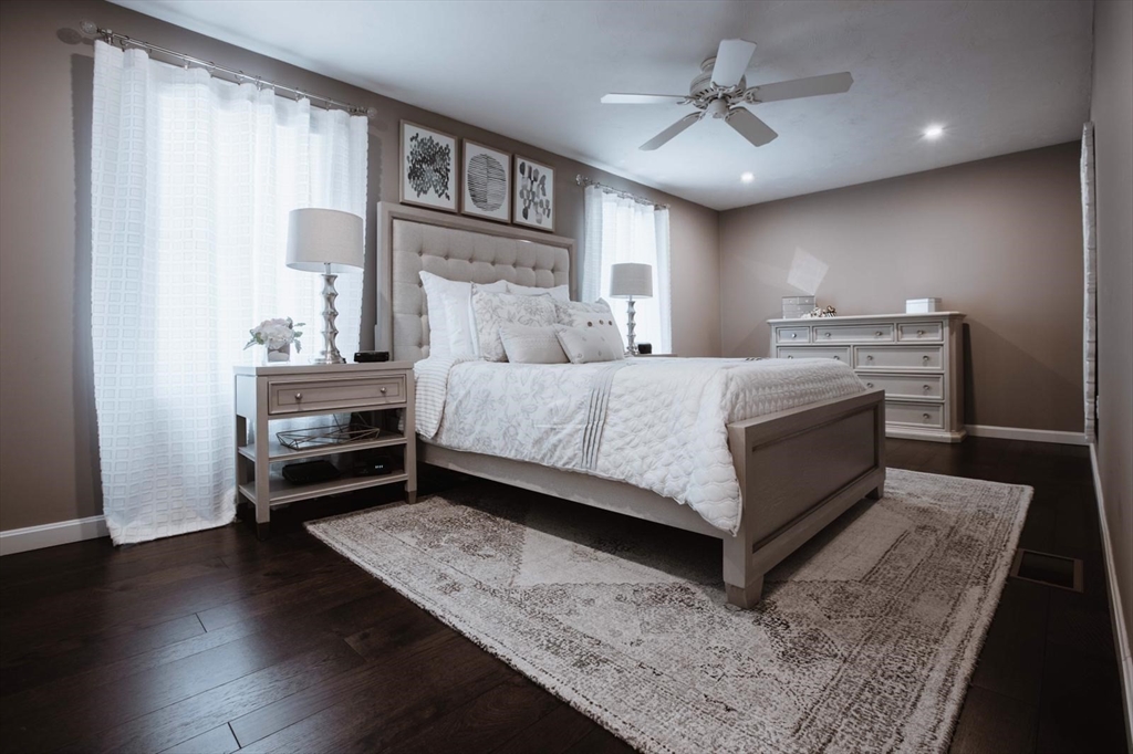 a bedroom with a bed wooden floor and window