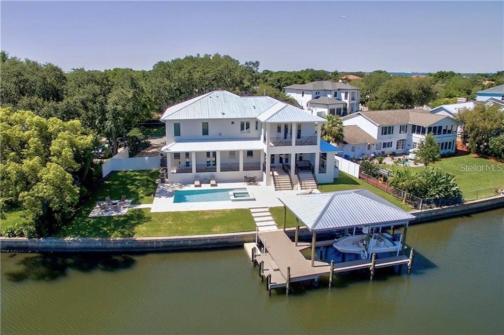 a view of a house with pool and chairs