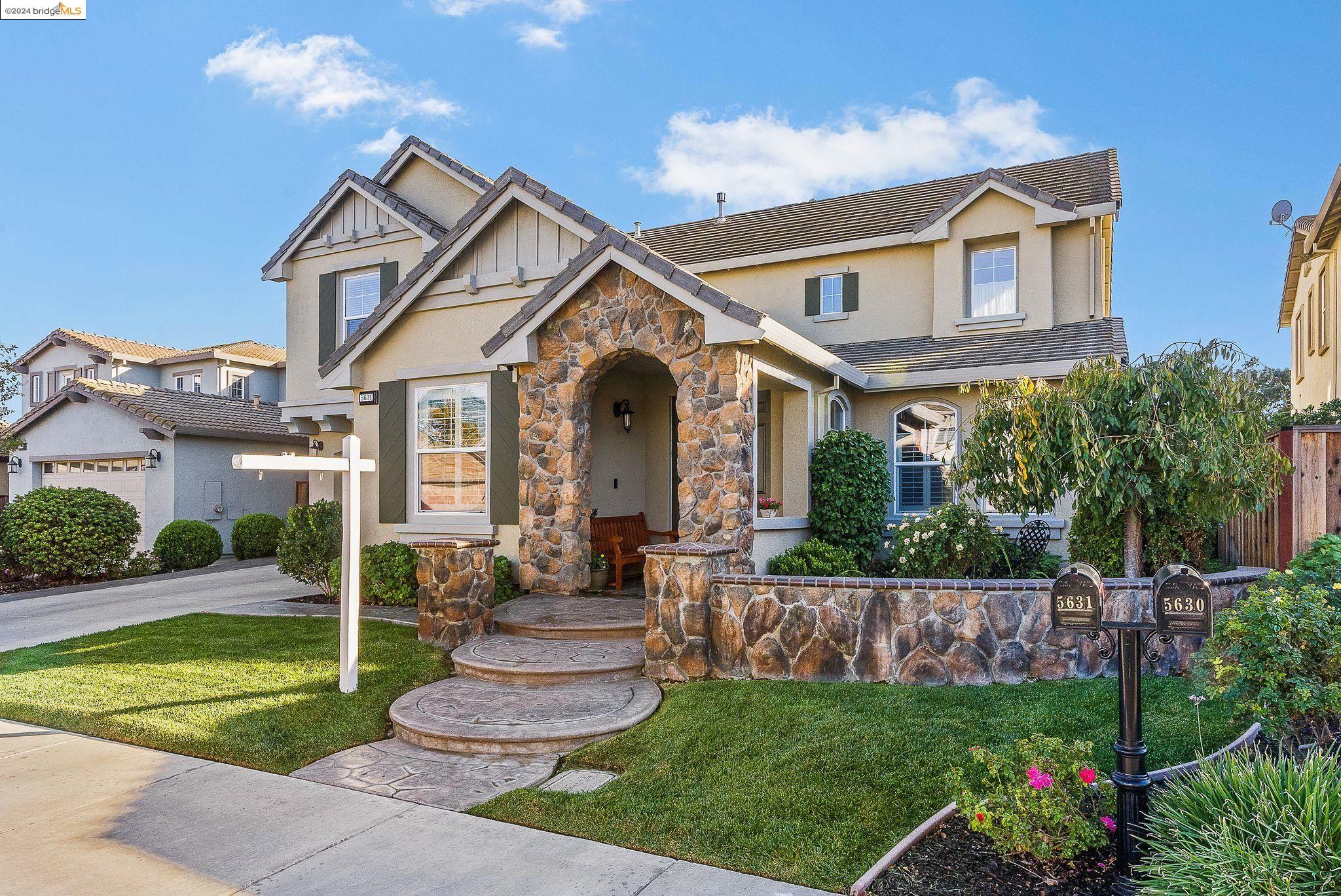 a front view of a house with a garden and plants