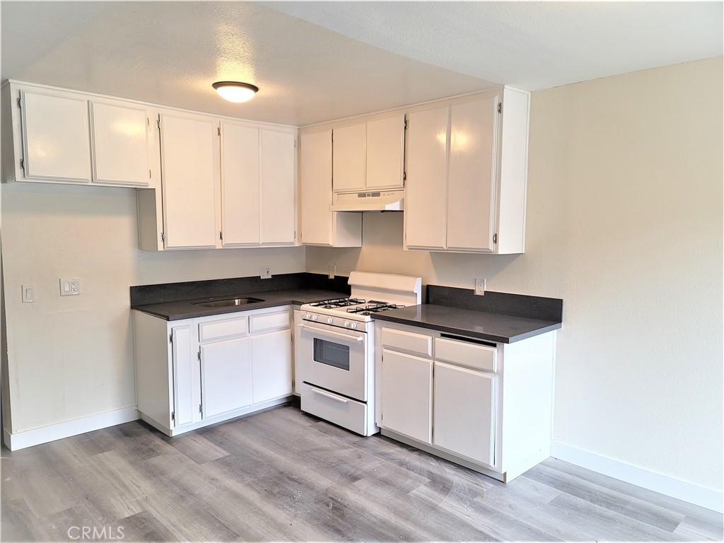 a kitchen with a stove and white cabinets