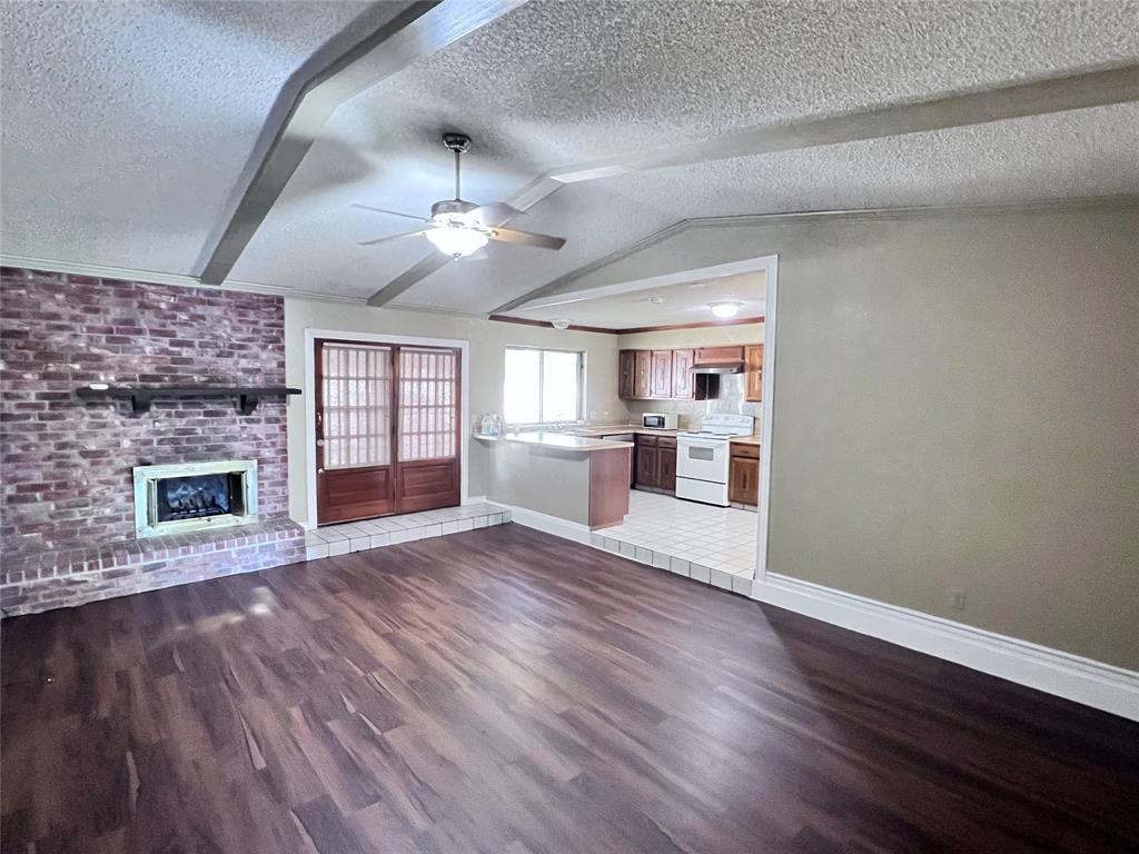 a view of empty room with wooden floor and fireplace