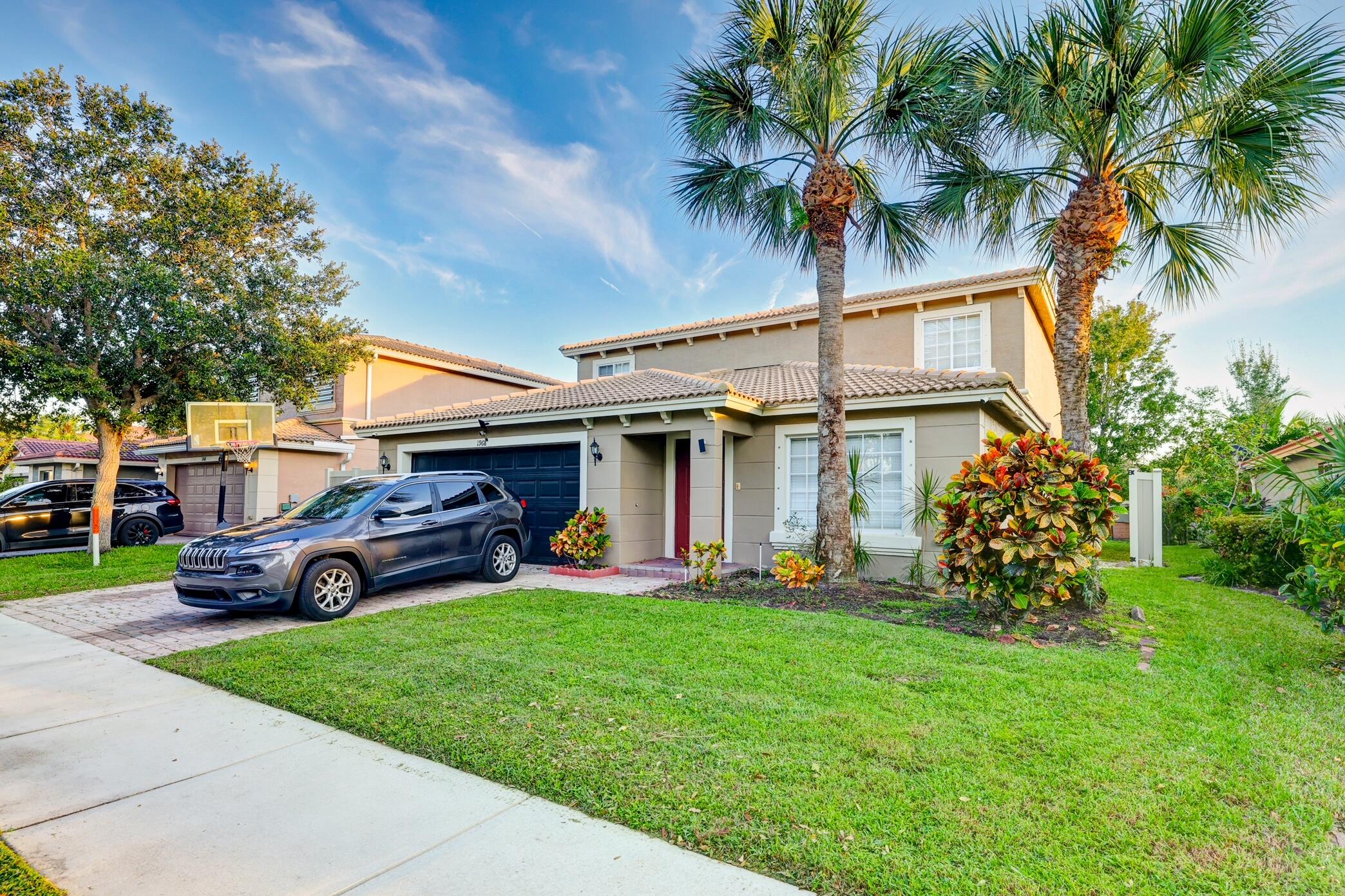 a view of a house with a yard and potted plants