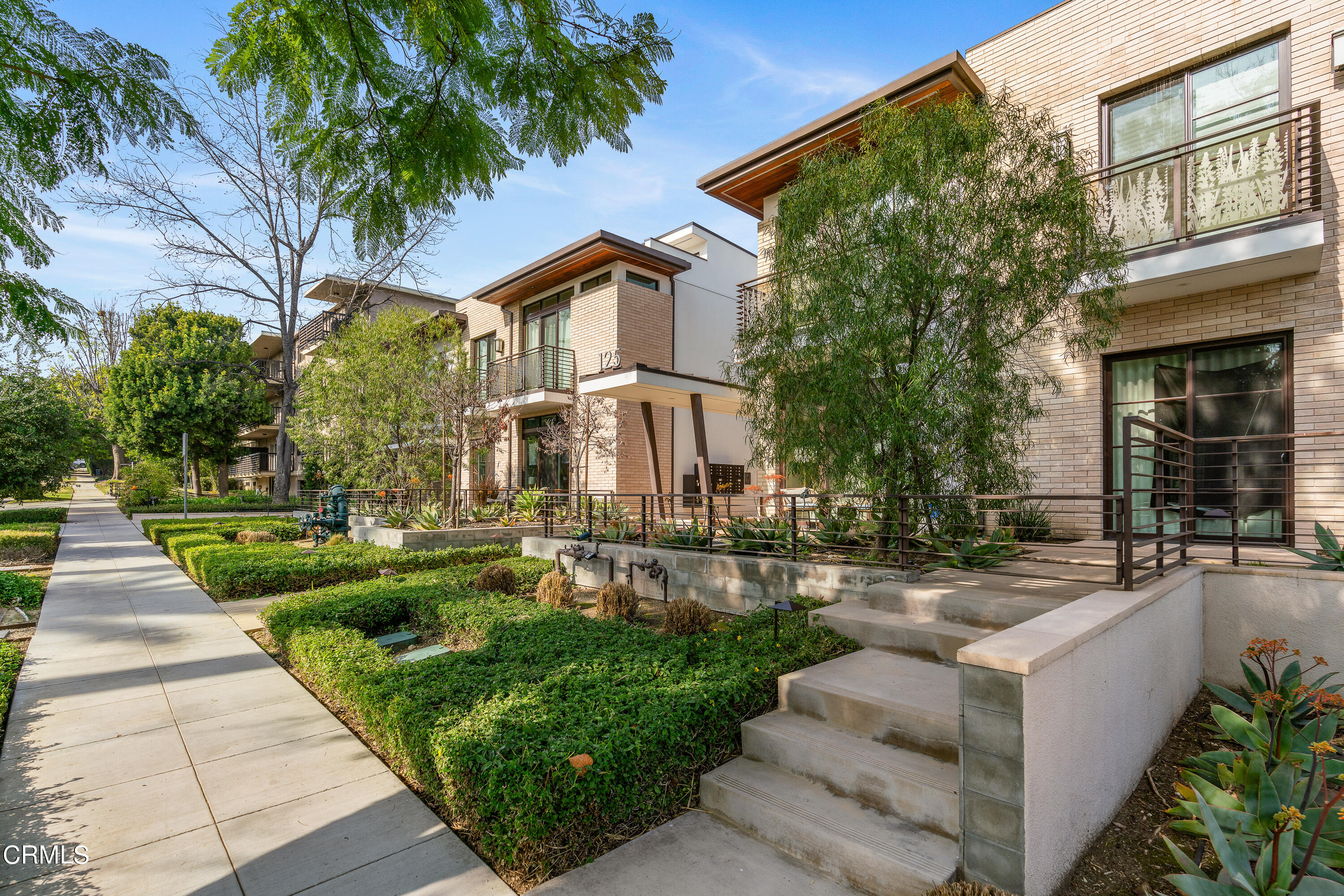 a front view of a house with a garden and plants