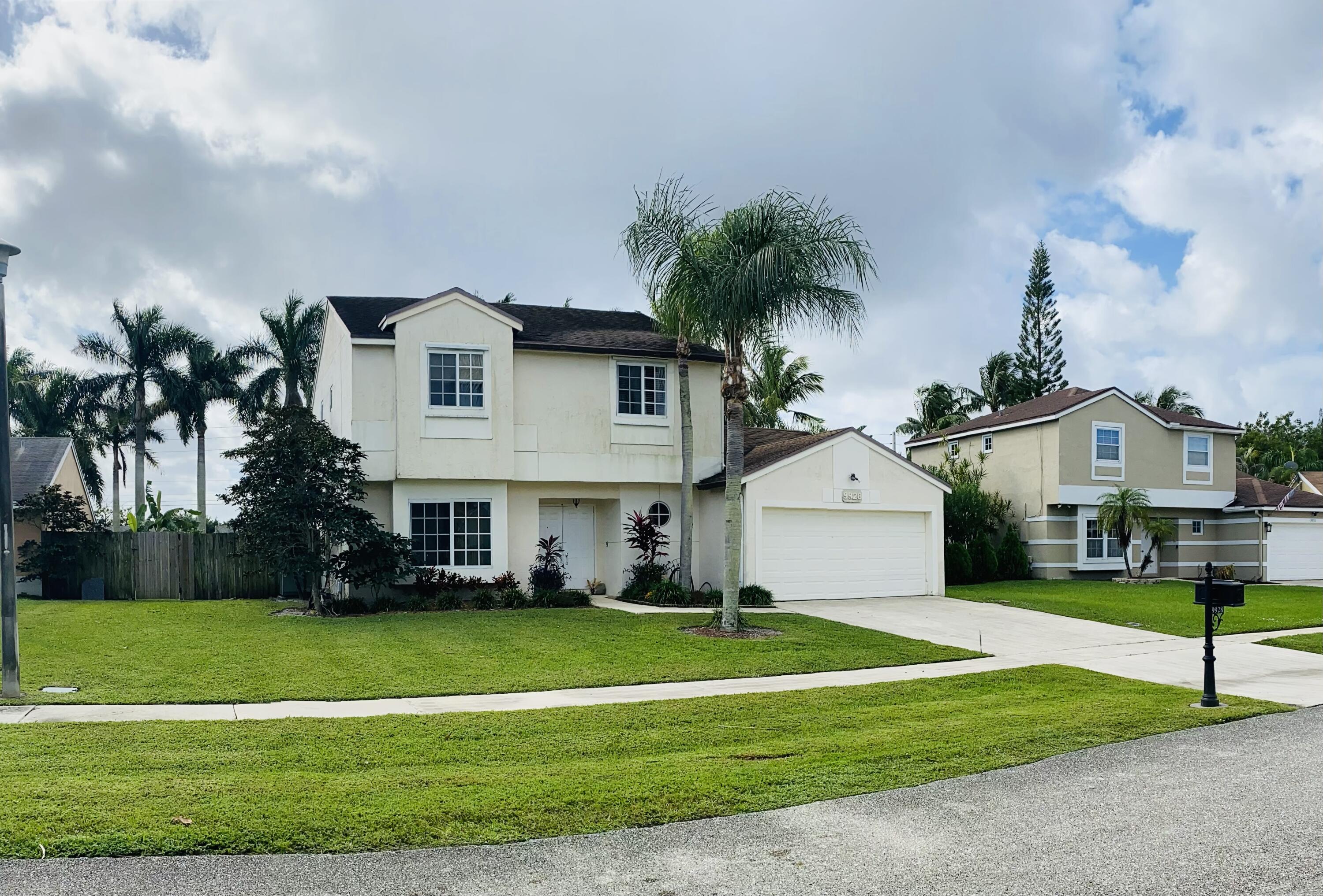 a front view of a house with a yard and trees