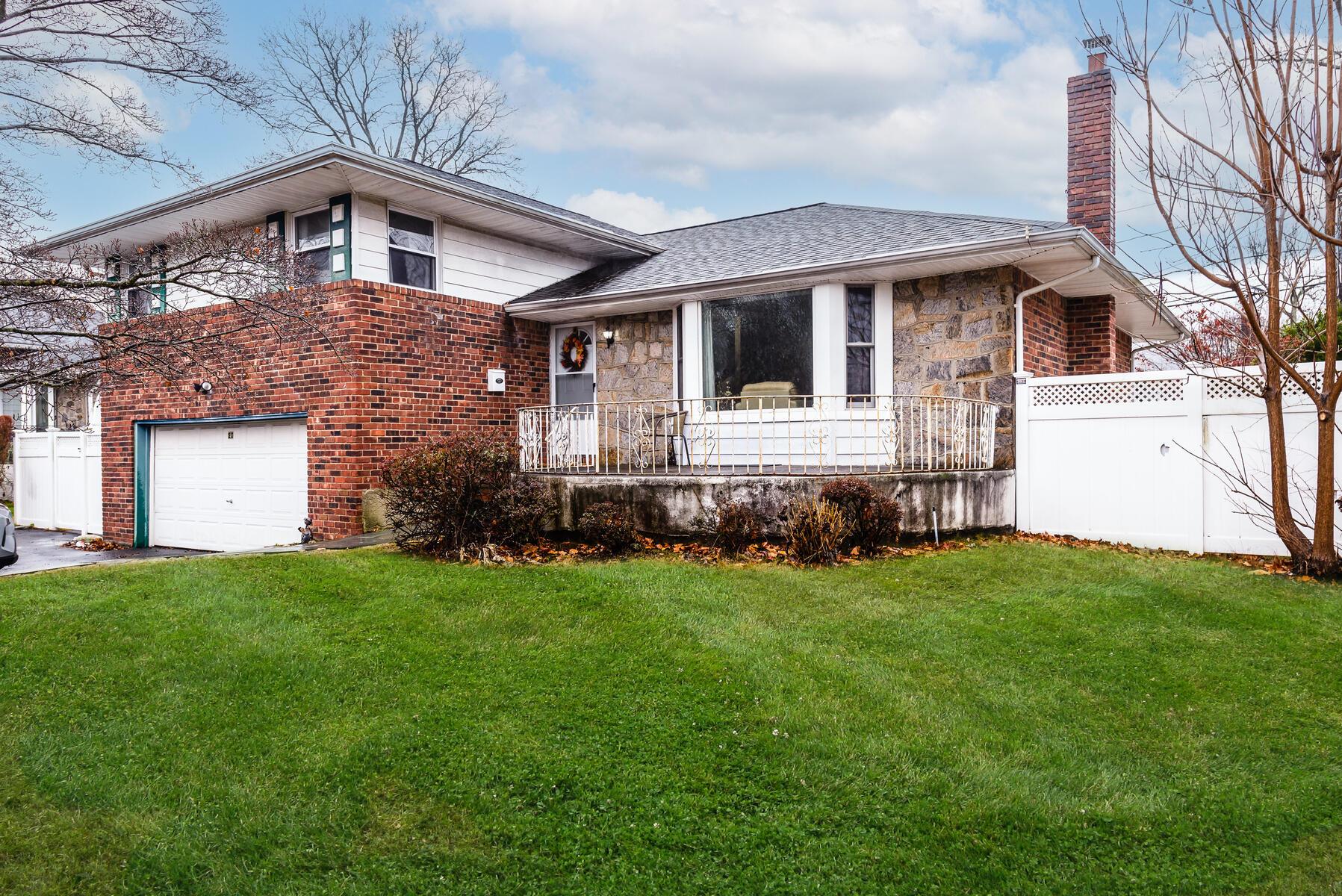 Split level home featuring a front yard and a 2-car garage