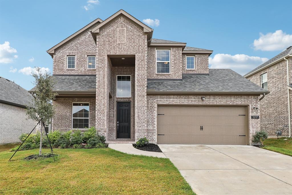 View of front property with a garage and a front lawn