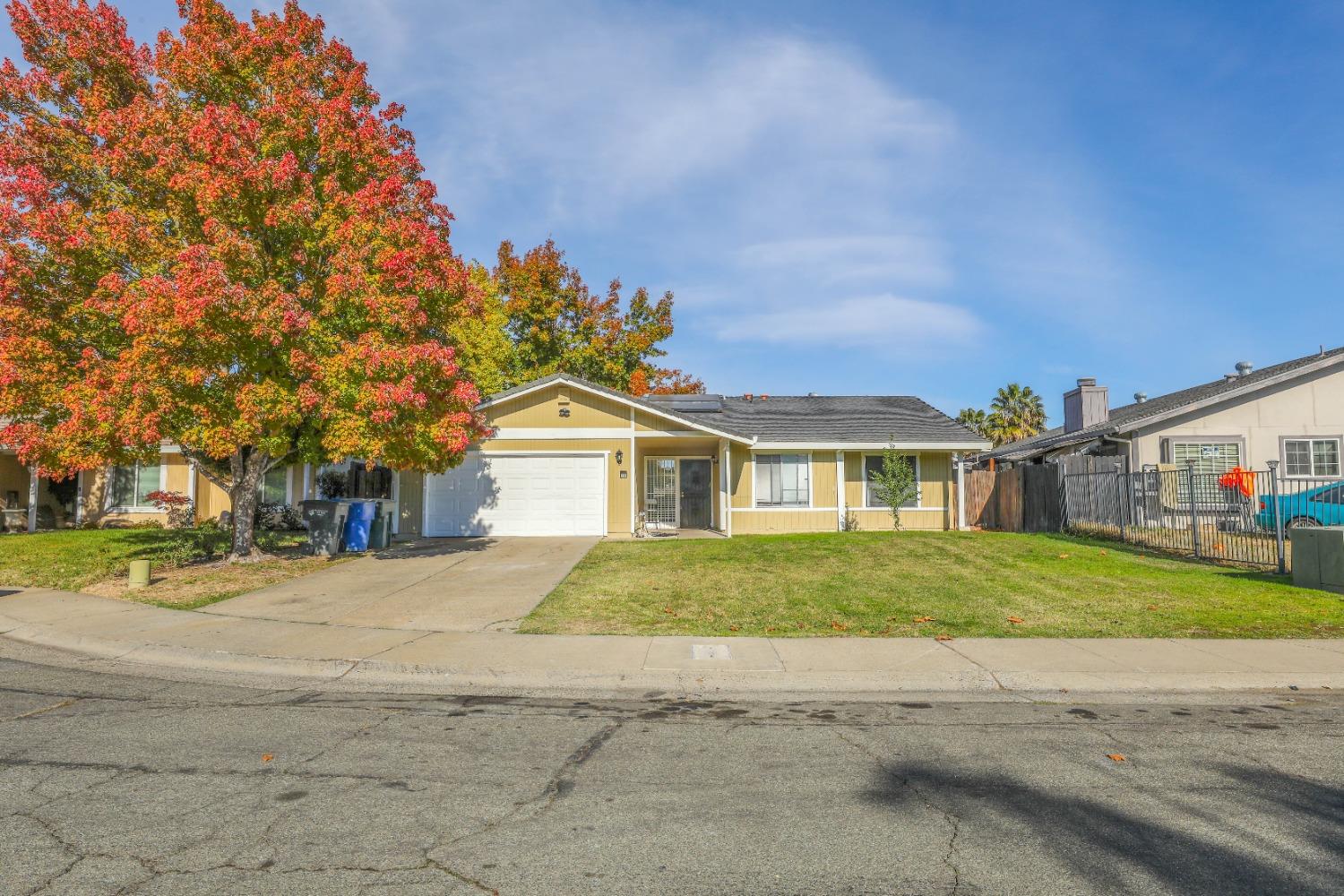 a front view of a house with a yard and trees