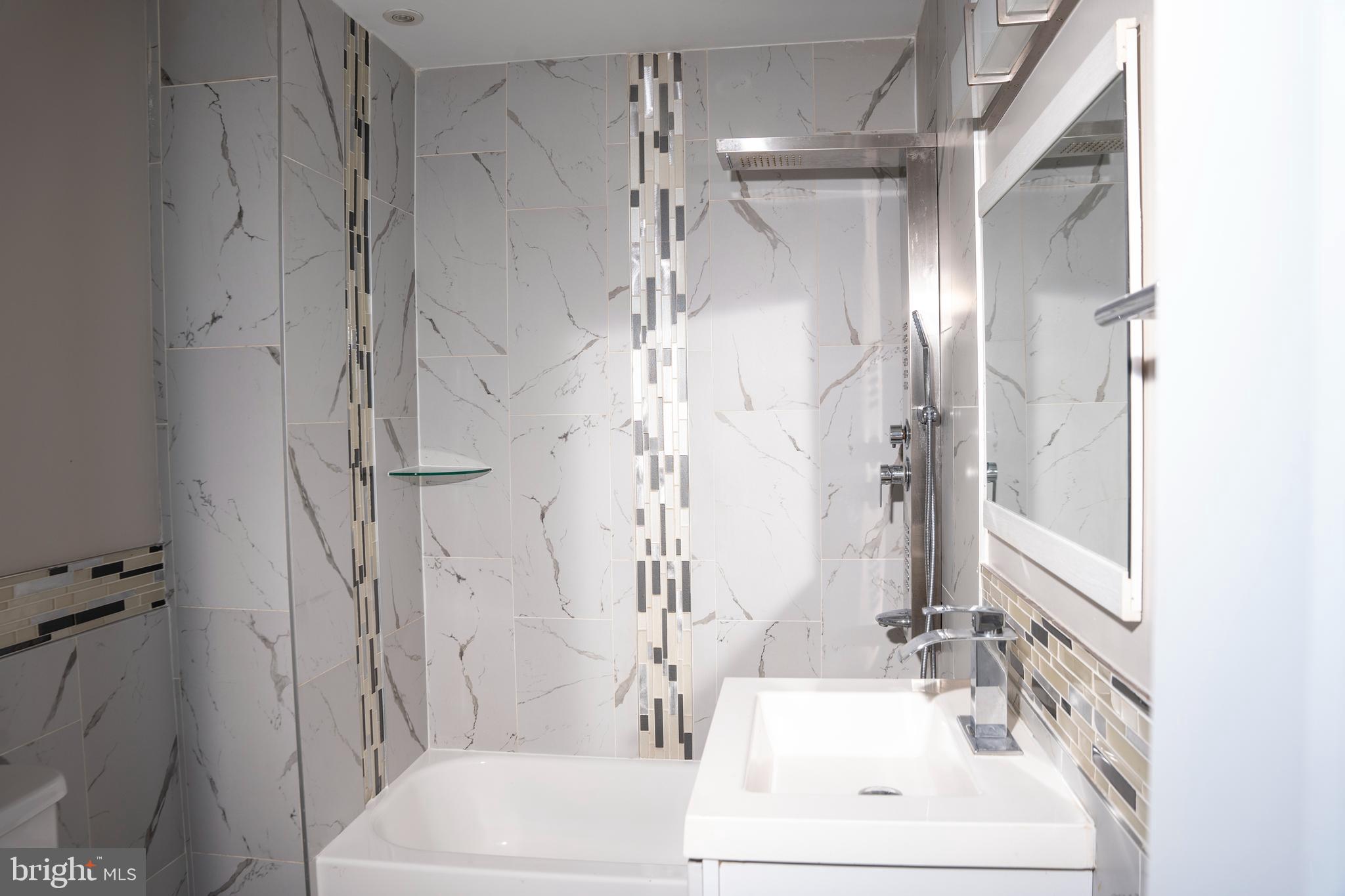 a bathroom with a bathtub shower sink and toilet