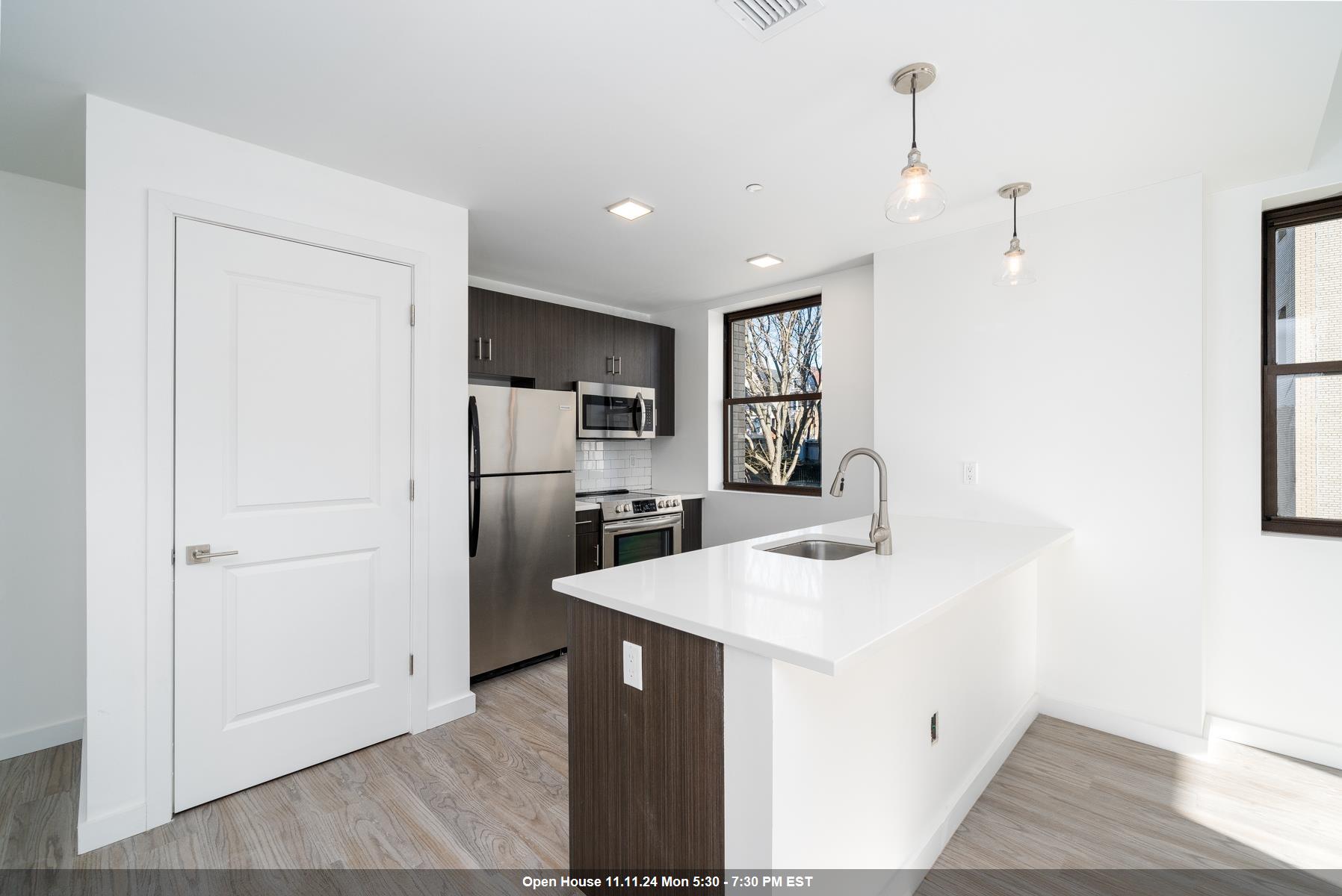 a kitchen with a sink a counter top space stainless steel appliances and cabinets