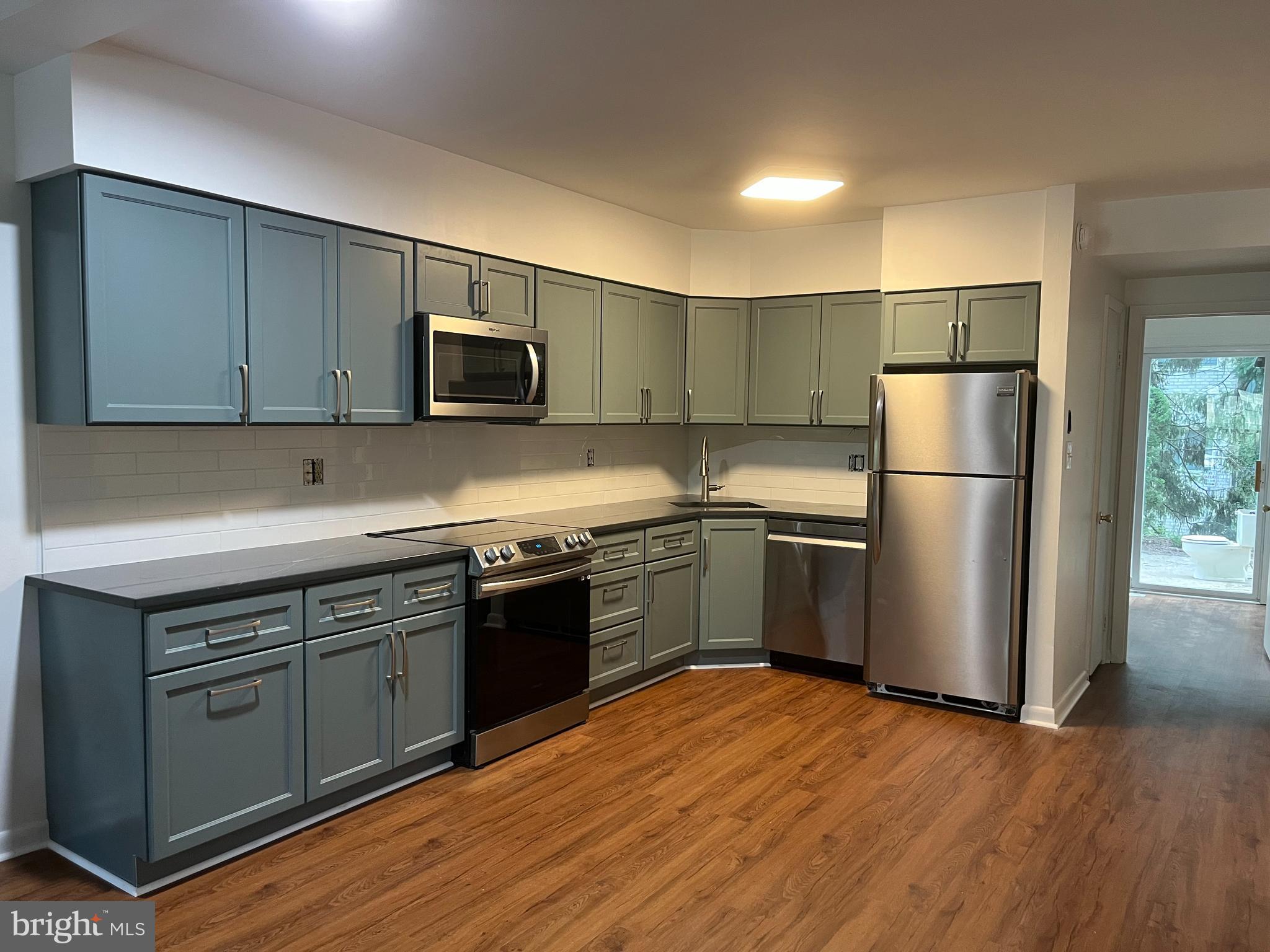 a kitchen with a refrigerator and a stove top oven