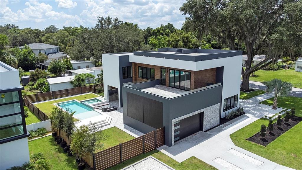 an aerial view of a house with swimming pool and furniture