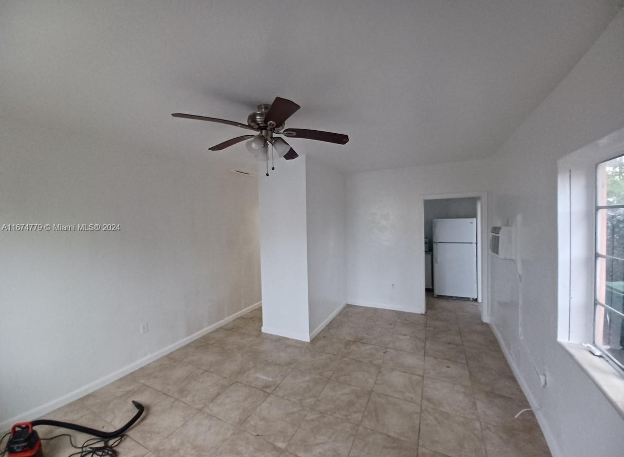 a view of a room with a ceiling fan and a window