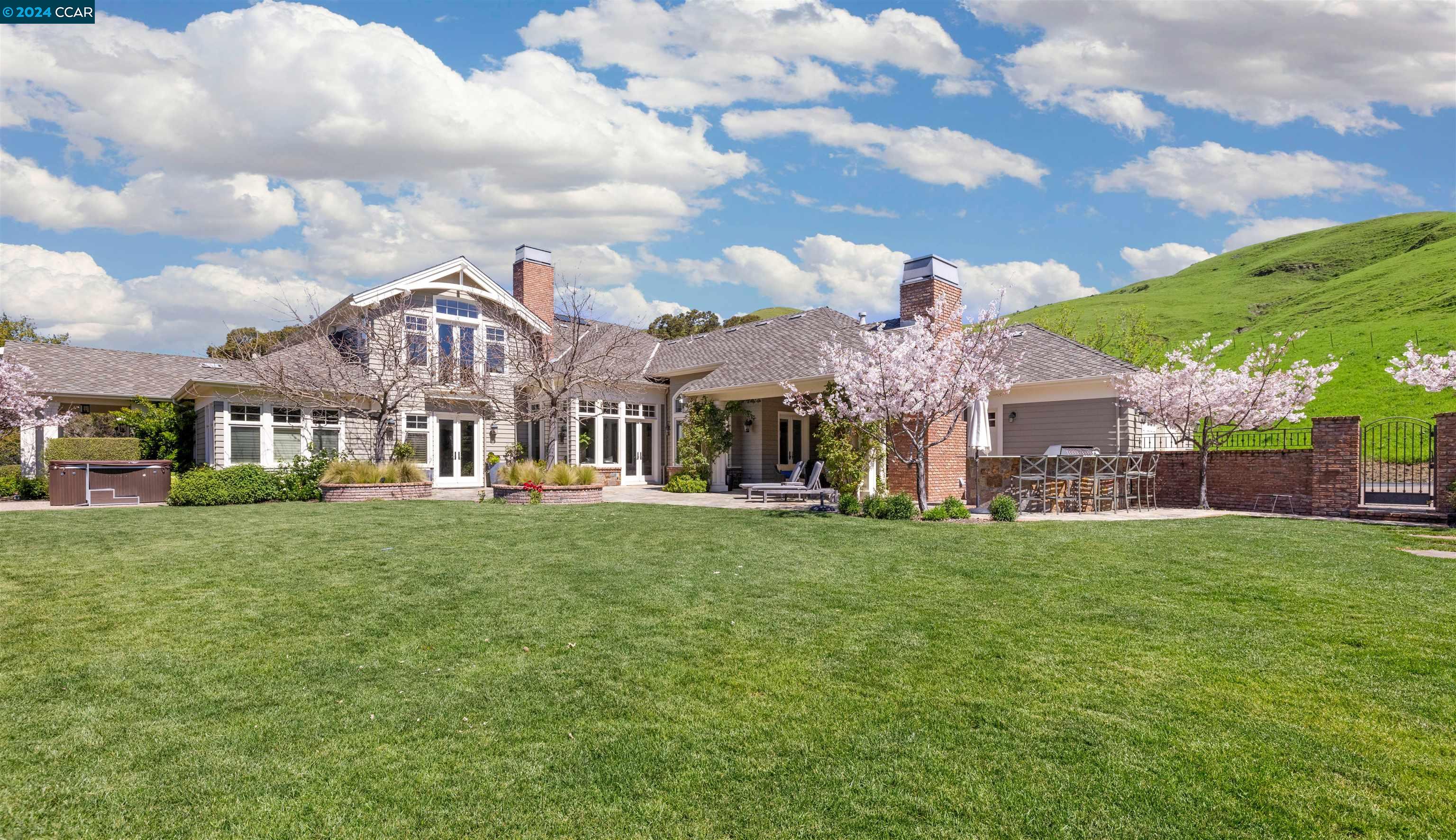 a view of a house with a big yard and a large tree