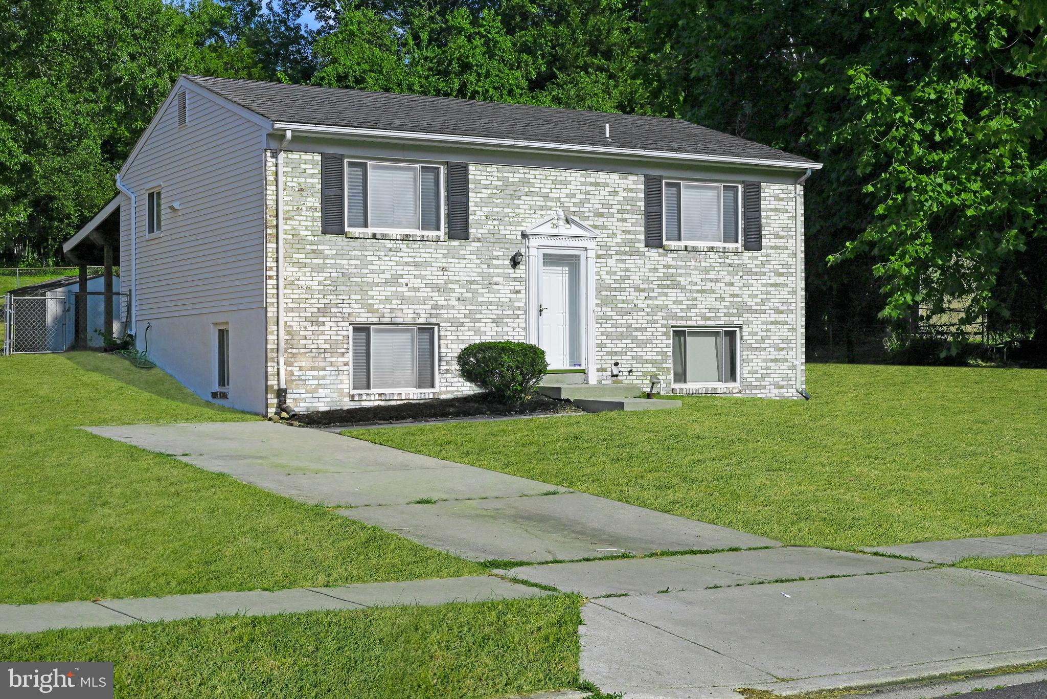 a view of a yard in front of a house with large windows