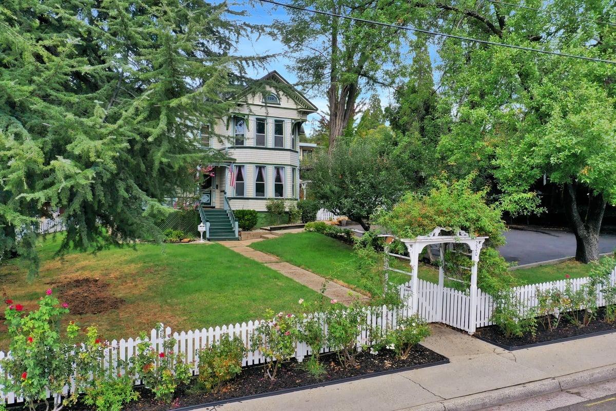 a front view of a house with a yard and potted plants