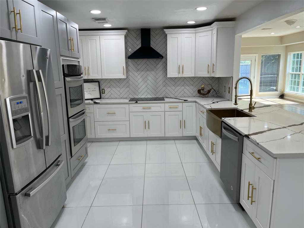 a kitchen with a refrigerator sink and cabinets