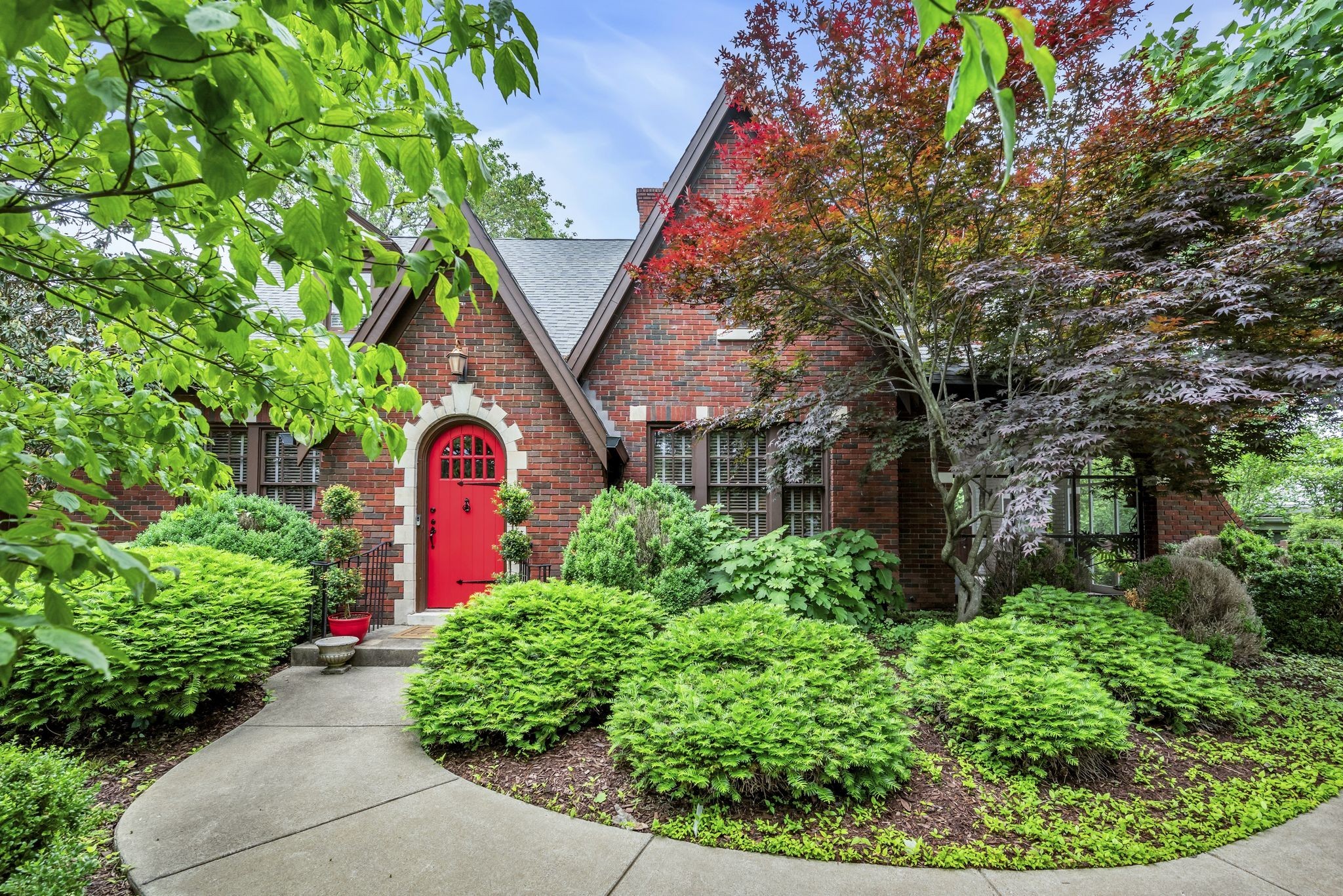 a front view of a house with a yard and fountain in middle