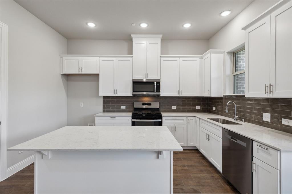 a kitchen with a sink a stove and cabinets