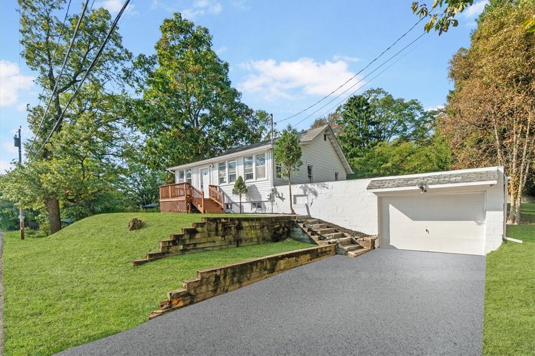 View of front of house featuring a front lawn and a garage