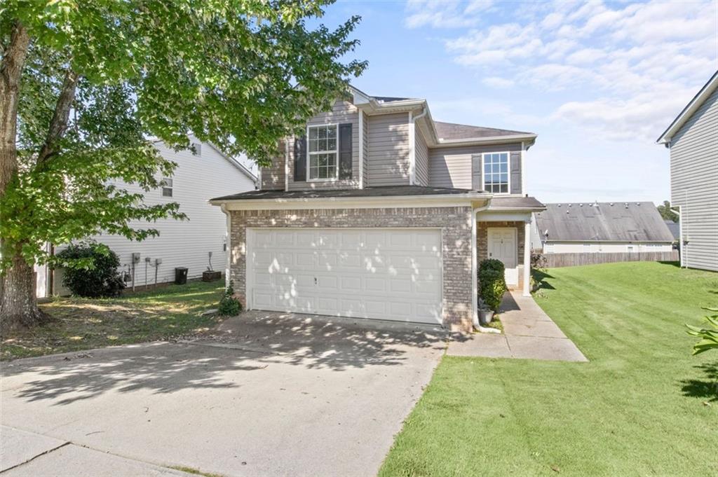 a front view of a house with a yard and tree