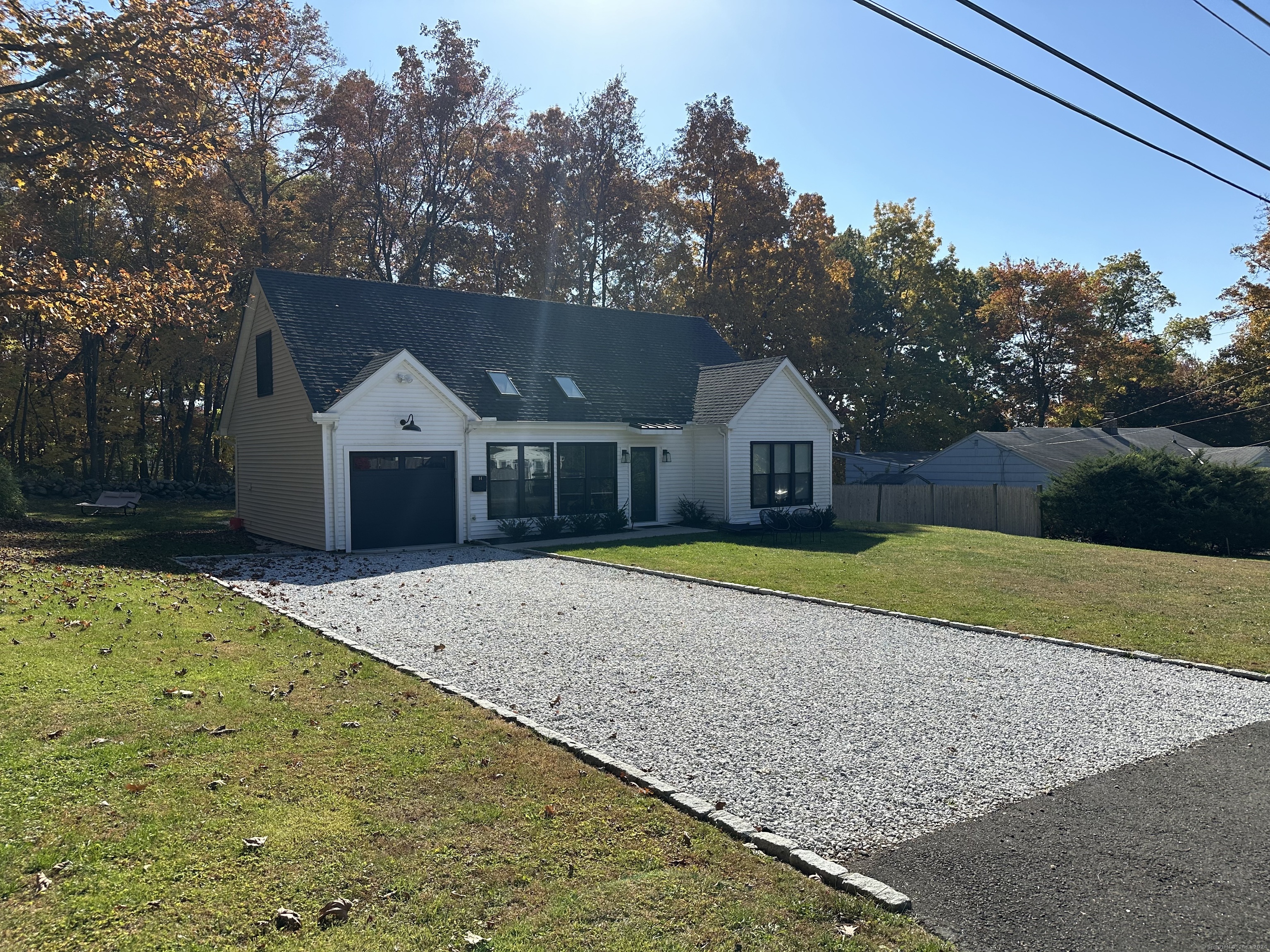 a front view of house with yard and trees in the background