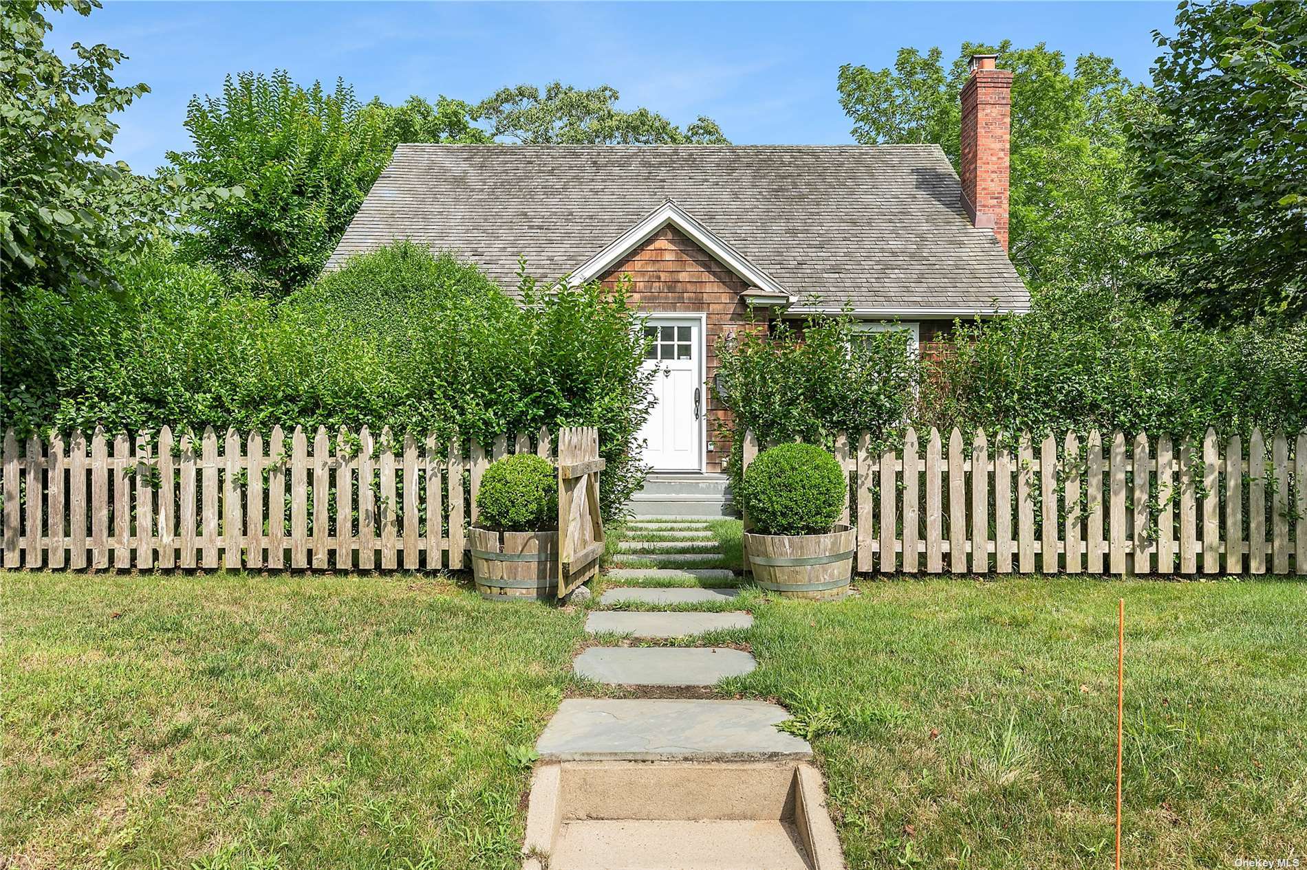 a front view of a house with a garden and plants