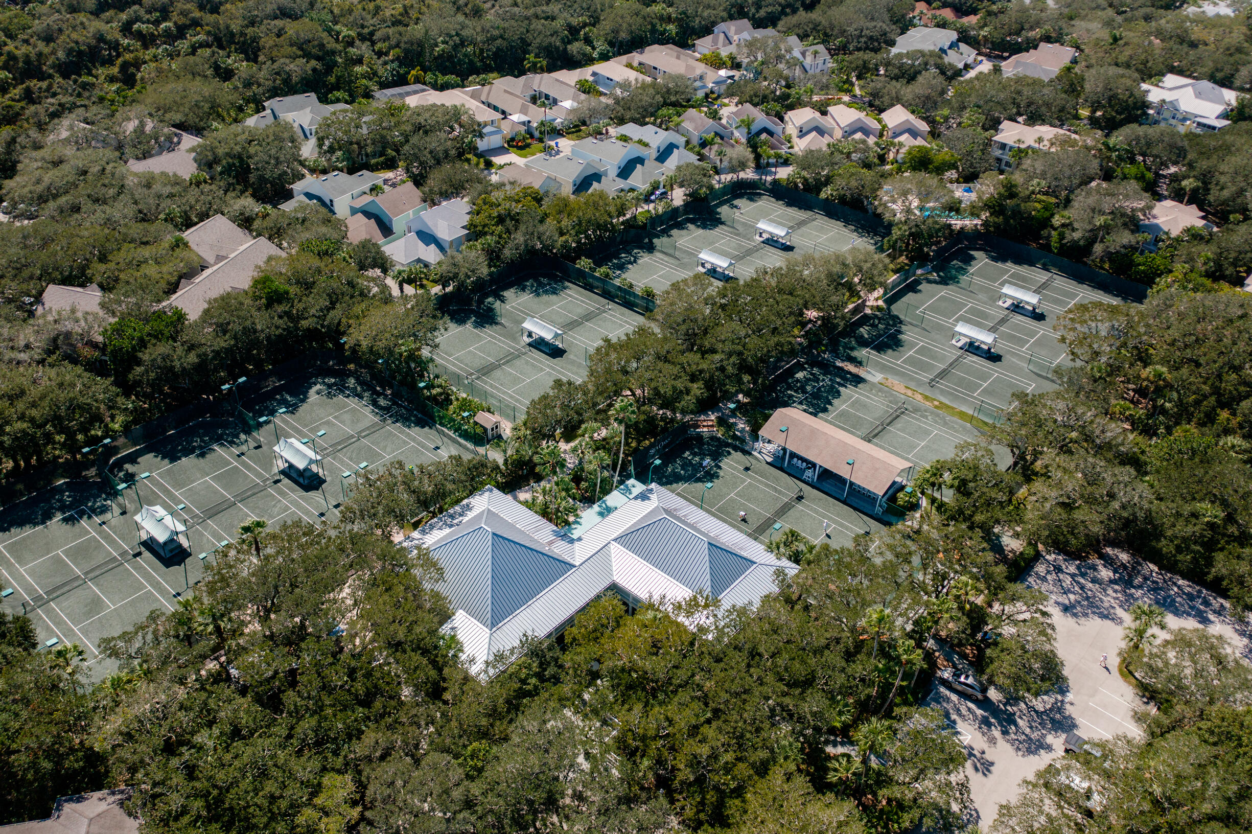 an aerial view of residential house with outdoor space and trees all around