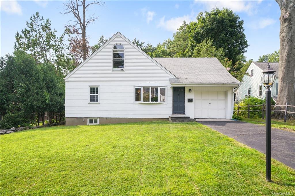 a view of a house with a yard and a tree